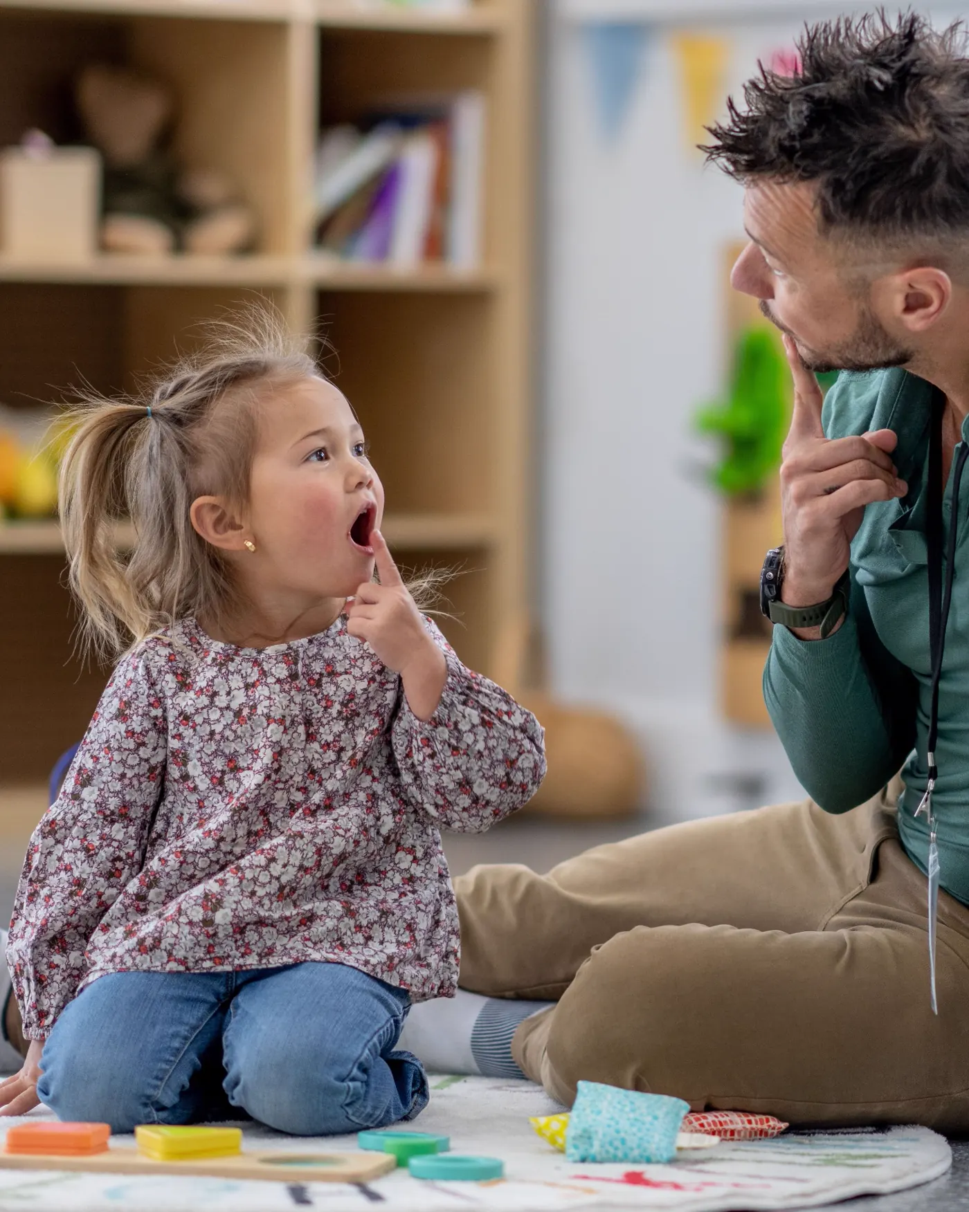 Child during speech therapy session with colorful toys